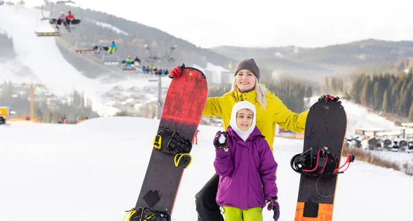 Mutter und Tochter mit Snowboards spielen im Schnee — Stockfoto
