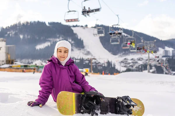 Sorridente menina feliz com snowboard no inverno ao ar livre — Fotografia de Stock
