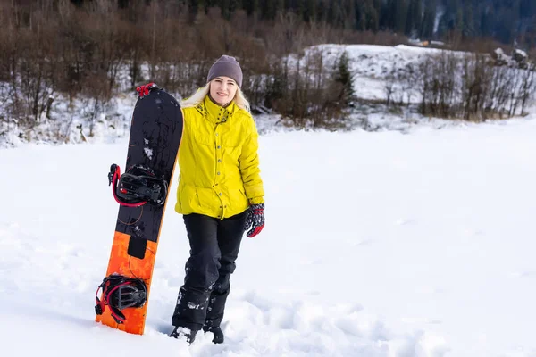 在冬季度假胜地拿着雪板的年轻女子 — 图库照片