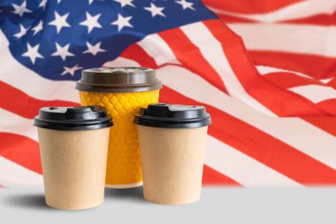 Amerikan bayrağına karşı bir fincan kağıt kahve. ABD kahve kavramına bayılır