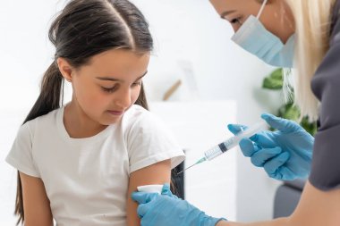 Doktor çocuk aşısı yapıyor.