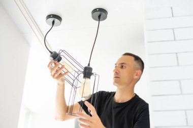 İçerideki tavan üzerinde lamba tamir eden işçiler