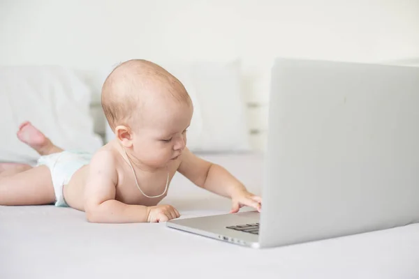 Een baby en een computer, hoofdfoto laptop — Stockfoto