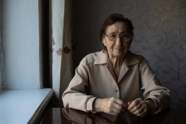 Çok yaşlı bir kadın gözlük takıyor.