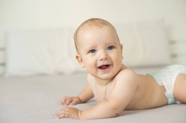 Beyaz yatak odasındaki sevimli erkek bebek. Yeni doğmuş çocuk yatakta dinleniyor. Aile sabahı evde..