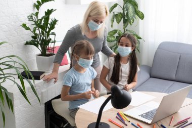 İnternette internet öğrenen iki küçük kız çocuğu annelerinin yardımıyla bilgisayar kullanarak, öğreterek ve teşvik ederek ev ödevi yapıyor. Kız ve kız kardeş evde birlikte eğitim almaktan mutlular.