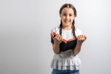 Kitabı olan zeki bir kız. İlkokulda bir çocuk. Çocuklar için eğitim ve öğrenim.