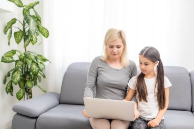 Yardımsever anne, kızına dizüstü bilgisayar kullanmasını anlatıyor.