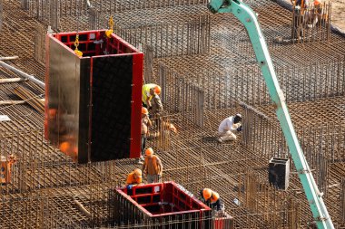 İnşaat alanında beton demirlerle çalışan işçiler.