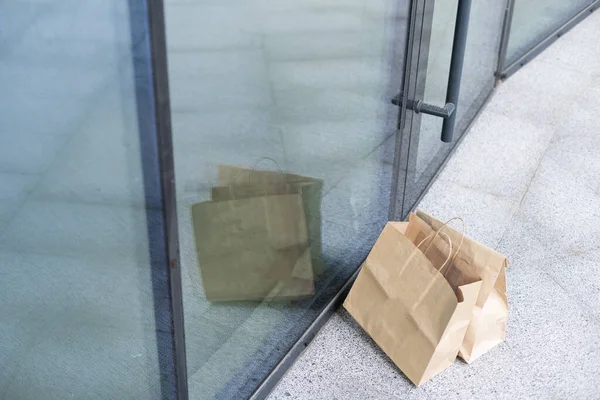 Bolsa de papel cerca de la puerta de la casa. Concepto de entrega segura. Entrega de comida a domicilio sin contacto. Medidas cautelares. —  Fotos de Stock