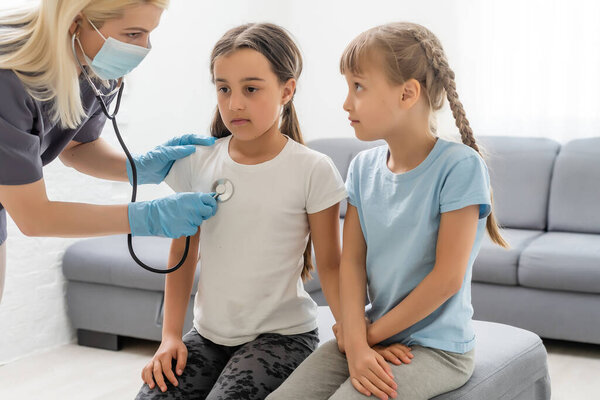 молодой врач с маленькой девочкой пациент чувствует себя плохо медицинский осмотр со стетоскопом.