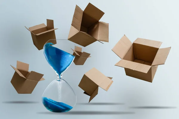 Cardboard boxes and an hourglass. Express delivery in short time concept. Temporary storage, limited offer and discount. Optimization of delivery logistics Transport company — Stock Photo, Image