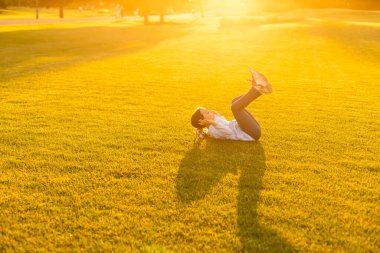 Küçük kız parkta jimnastik yapıyor.