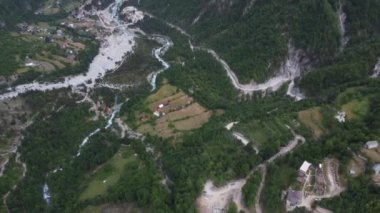 Theth Ulusal Parkı, Arnavutluk. Gün doğumunda Alp Dağları 'nın havadan görünüşü. Thethi köyü ve görkemli dağlara bakan yeşil ağaçların üzerinden uçuyorlar. Arnavutluk 'taki Lanetli Dağlar Prokletije