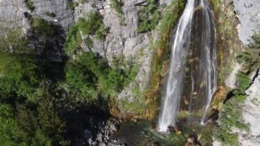 Arnavutluk 'un dağlarındaki Theth köyü yakınlarındaki güzel Theth şelalesi. Yavaş çekimde ormana çağlayan heybetli şelale, lanetli dağlar, Arnavutluk