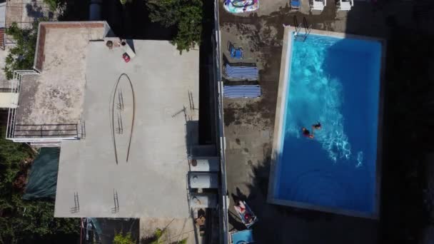 La madre con su hijita se divierte en la piscina. Mamá juega con el niño. La familia disfruta de vacaciones de verano en una piscina. — Vídeos de Stock