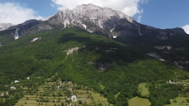 アルバニア国立公園に指定。日の出にアルバニアンアルプスの空中ビュー。テティ村と雄大な山々を見下ろす緑の木々の上を飛ぶ。アルバニアの呪われた山｜Prokletije — ストック動画