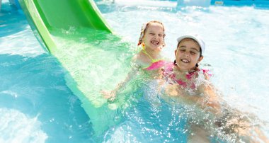 İki küçük kız havuza atlarken eğleniyor.