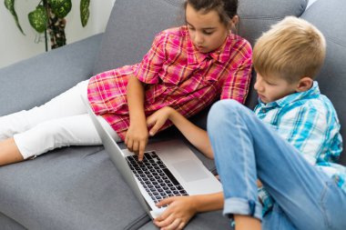 Tatlı çocuklar eğitim için dizüstü bilgisayar, online çalışma, evde öğrenim, uzaktan öğrenim gören kız ve erkek çocukları. Evde eğitim için yaşam tarzı kavramı.