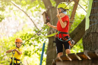 Çocuk tırmanışçı ip köprüde yürüyor,