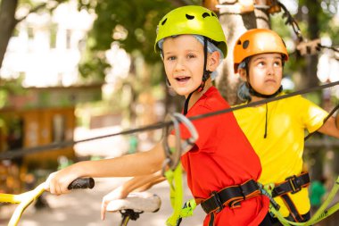 Çocuk tırmanışçı ip köprüde yürüyor,