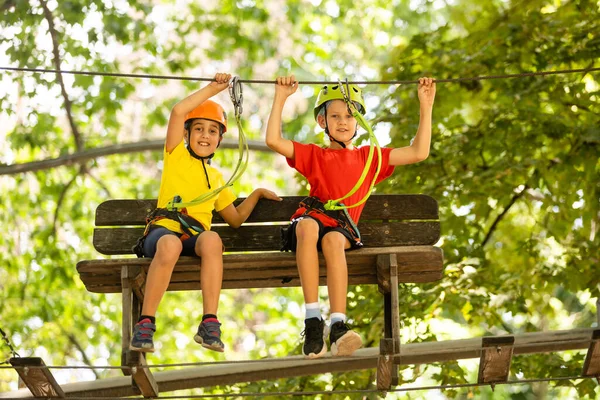 Feliz niño trepando a los árboles. Parque de cuerdas. Niño escalador. Desarrollo de la primera infancia. Parque de cuerdas. Puentes de cuerda y viga de equilibrio. Parque de cuerdas - centro de escalada — Foto de Stock