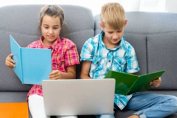 Jonge jongen met een laptop computer zitten in de buurt van een meisje — Stockfoto