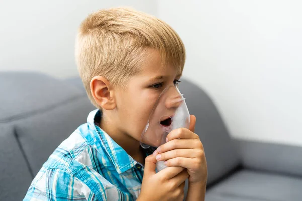 Menino fazendo inalação com nebulizador em casa. — Fotografia de Stock