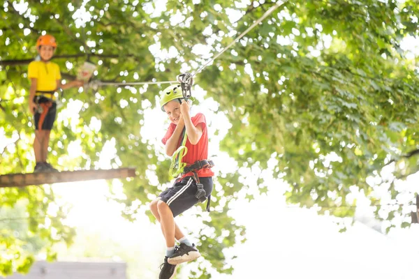 Aventura escalada alto fio parque - menino no curso em capacete de montanha e equipamentos de segurança — Fotografia de Stock