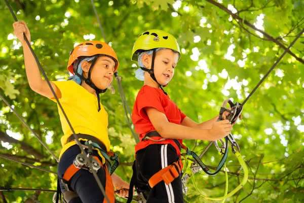 Des enfants mignons. Garçon et fille grimpant dans une structure de terrain de jeu de corde au parc d'aventure — Photo