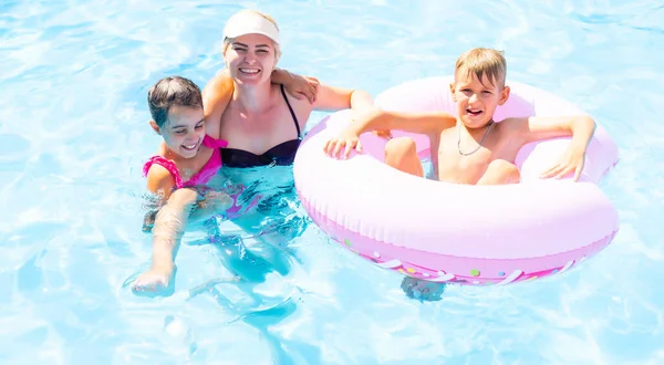 Familia joven, padres con niños, en la piscina — Foto de Stock