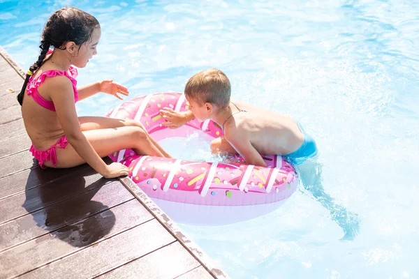 Niños divirtiéndose jugando en la piscina en las vacaciones de verano — Foto de Stock