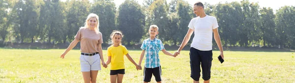 Familia feliz jugando en el campo verde — Foto de Stock