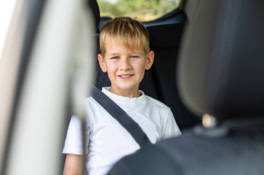 Arabadaki emniyet kemeri ile bükülmüş genç küçük çocuk