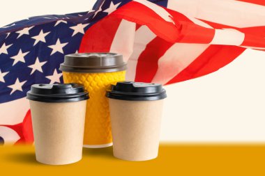 Amerikan bayrağına karşı bir fincan kağıt kahve. ABD kahve kavramına bayılır
