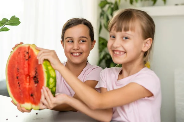 Dwoje dzieci jedzących jeden kawałek arbuza. Dzieci jedzą owoce na dworze. Zdrowa przekąska dla dzieci. — Zdjęcie stockowe