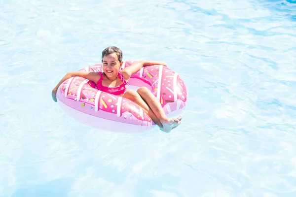 Adorable petite fille avec anneau gonflable à la piscine — Photo