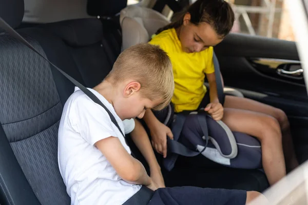 Glada barn, bedårande barn girl med tonåring bror sitter tillsammans i modern bil låst med bilbälten som njuter av semester med familjen resa på sommaren helgen — Stockfoto