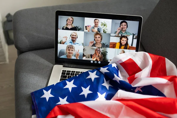 Fiesta en línea con seres queridos de Estados Unidos. Celebrando el video chat de Navidad. Fiesta virtual a través de mensajero de vídeo. Los estadounidenses de año nuevo son el chat de vídeo. Regalos de Año Nuevo y bandera de América al lado de la computadora — Foto de Stock