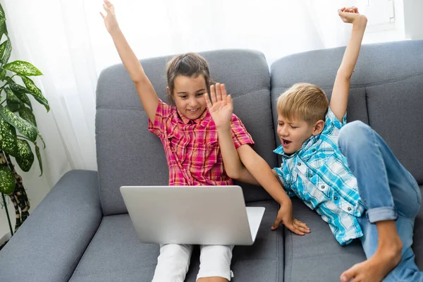 Jongen en meisje, broer en zus studeren thuis. Een meisje kijkt naar een videoles of een online conferentie. — Stockfoto