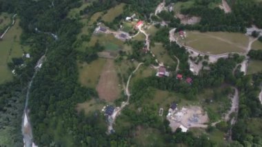 Theth Ulusal Parkı, Arnavutluk. Gün doğumunda Alp Dağları 'nın havadan görünüşü. Thethi köyü ve görkemli dağlara bakan yeşil ağaçların üzerinden uçuyorlar. Arnavutluk 'taki Lanetli Dağlar Prokletije