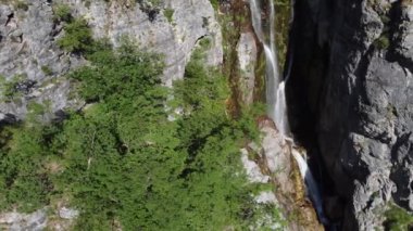 Arnavutluk 'un dağlarındaki Theth köyü yakınlarındaki güzel Theth şelalesi. Yavaş çekimde ormana çağlayan heybetli şelale, lanetli dağlar, Arnavutluk