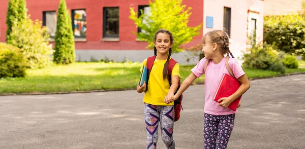 Terug naar school. Eerste schooldag. Twee tienermeisjes op school die zich gelukkig en opgewonden voelen. — Stockfoto