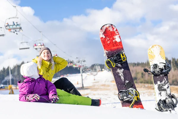 Mãe e filha com snowboards em um resort de montanha — Fotografia de Stock