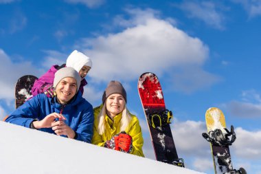 Kışın snowboard yapan bir aile.