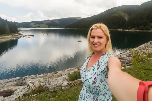 Придивіться до жінки - туристки, яка йде по стежці в Альпах поблизу Ервальда, Тіроль, Австрія. Ландшафт з травою, деревами, скелястими горами і блакитним небом.. — стокове фото