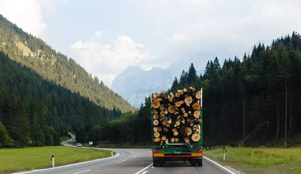 Ein großer LKW transportiert Holz auf einer Bergstraße — Stockfoto