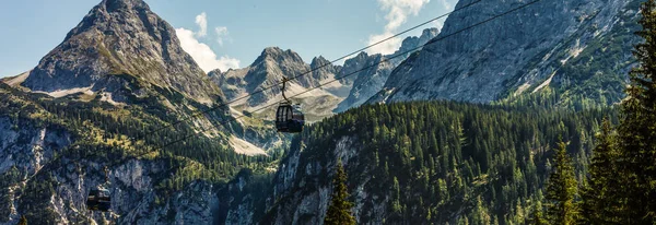Two cabs of the cableway and skiers on the slope of the mountain Chopok south side on a sunny day in the ski — Stock Photo, Image