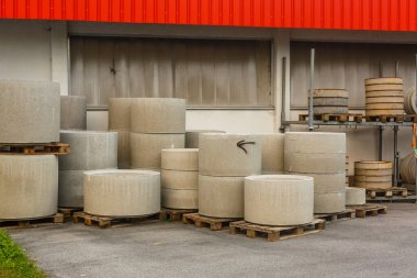 Farklı çap ve gri beton yüzük Wells'le sokakta yalan