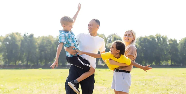 Boldog család sétál a mezőn és fogja egymás kezét — Stock Fotó